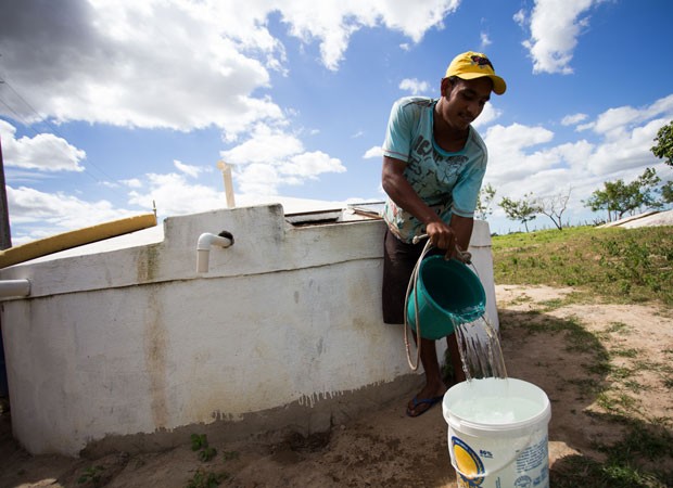 Morador de Olho d'Água das Flores, em Alagoas, pega água de cisterna vizinha (Foto: Jonathan Lins/G1 AL)