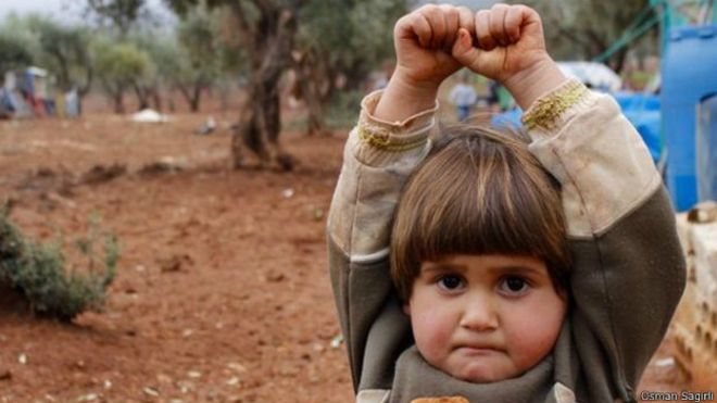 crianca siria se rende a camera fotografica